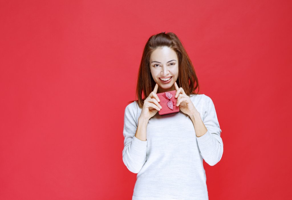 young-woman-in-white-shirt-holding-a-small-red-gift-box.jpg