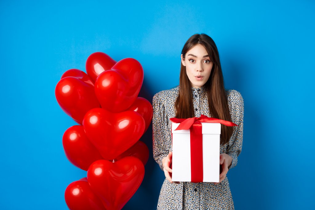 valentines-day-surprised-attractive-girl-looking-amazed-at-camera-holding-big-romantic-gift-standing.jpg