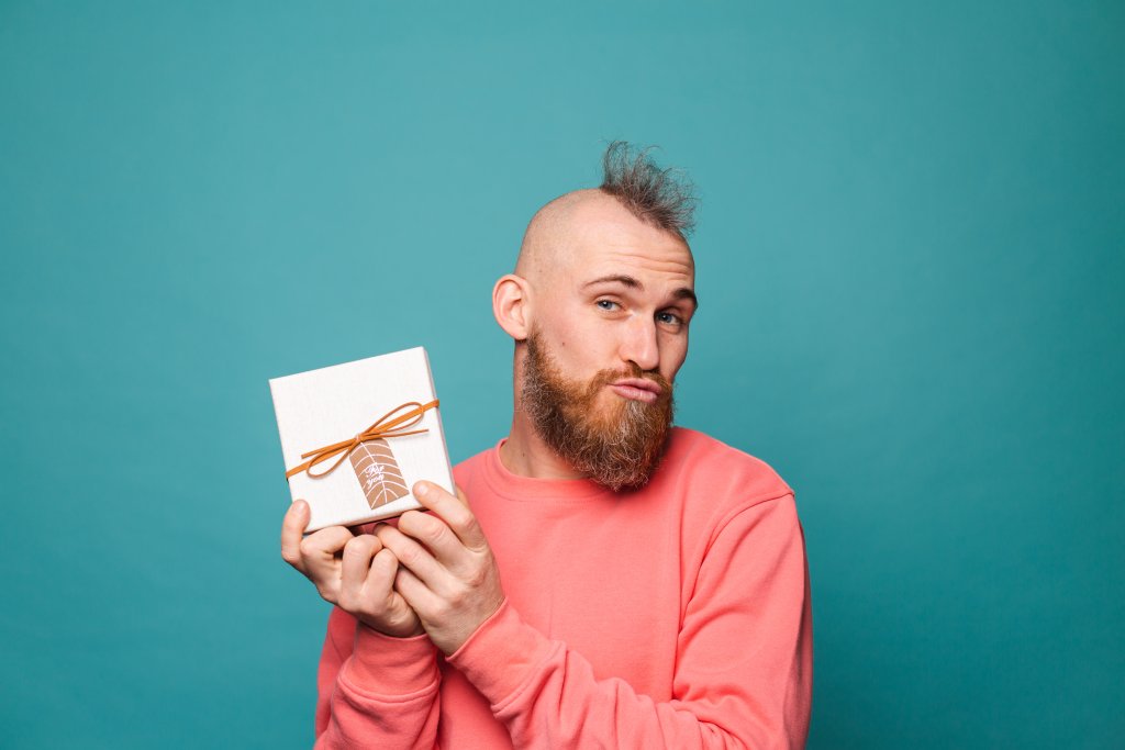 bearded-european-man-in-casual-peach-isolated-excited-cheerful-holding-gift-box.jpg